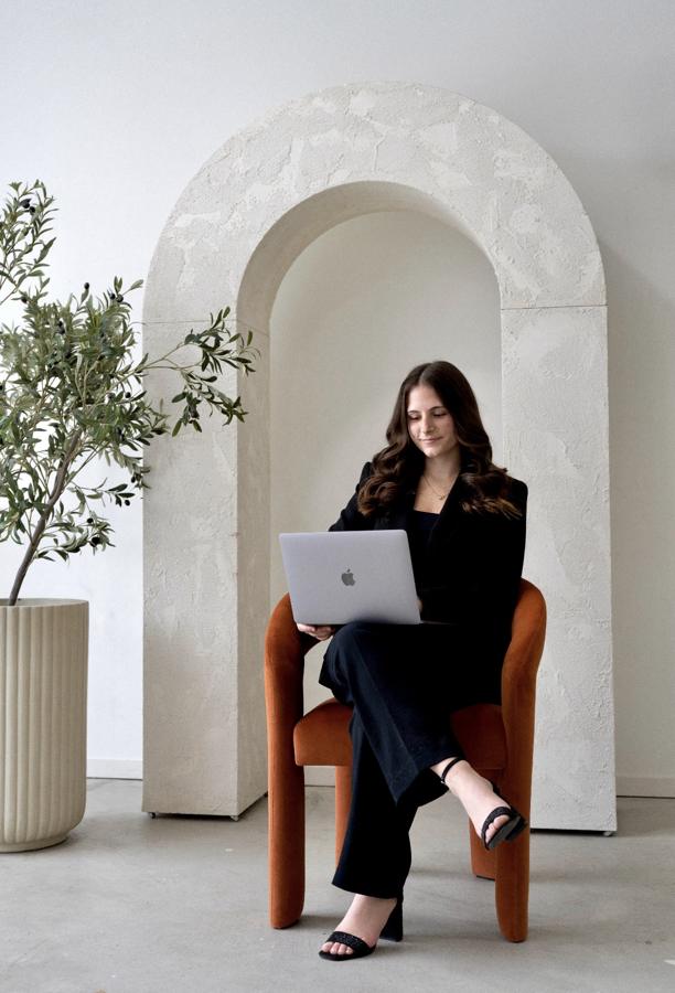 Ashley Hoover working on her laptop in an armchair